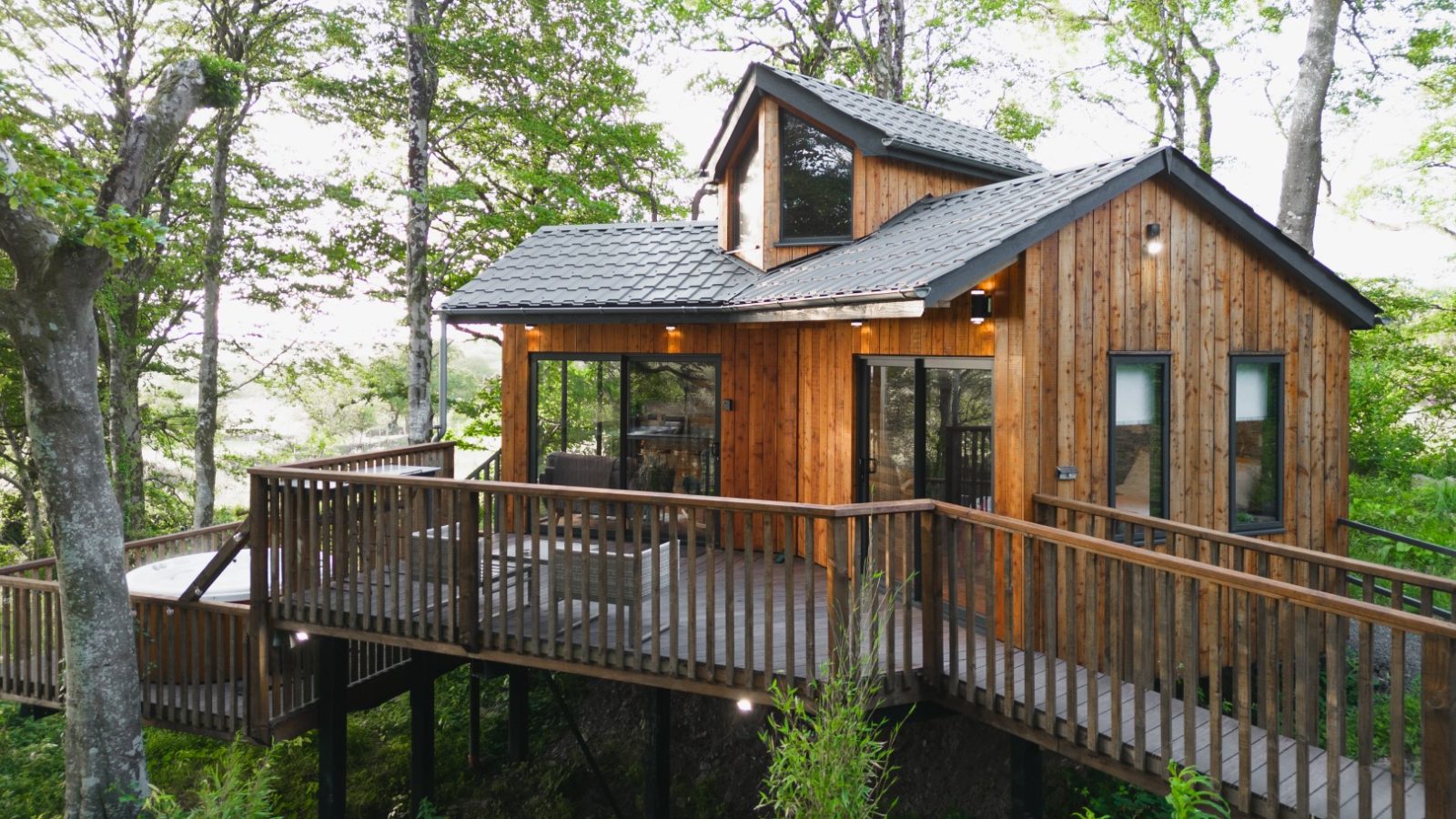 Cuckoos Hideaway is a charming wooden cabin with large windows and a wraparound deck, elevated on stilts. Nestled among trees in a serene forest setting, it's the perfect escape for nature lovers.