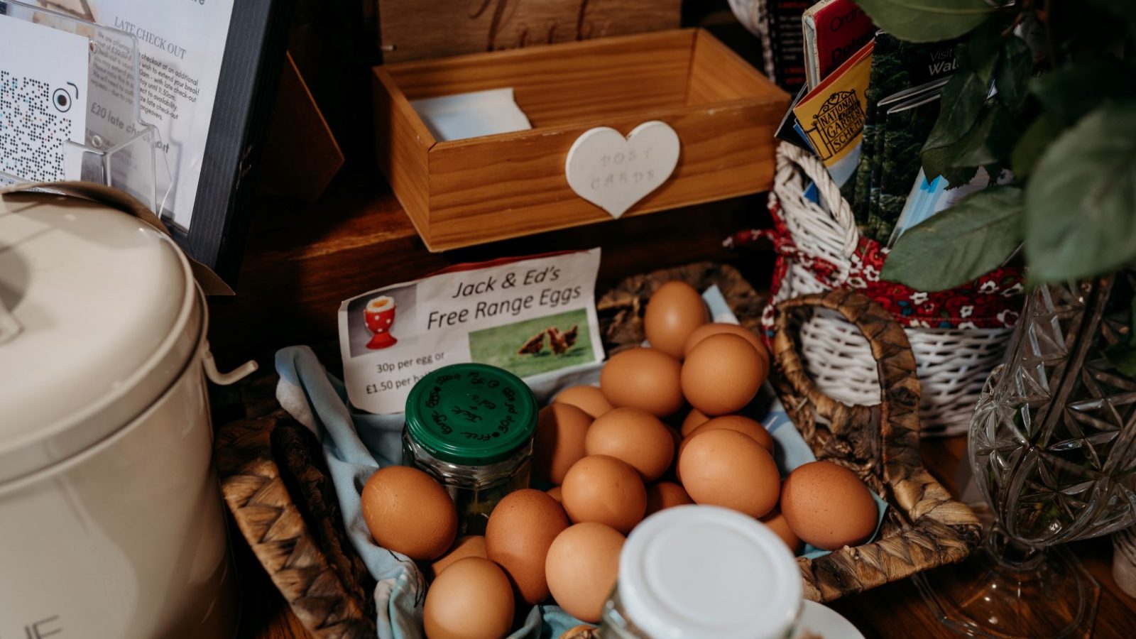 A basket filled with brown eggs sits on a table, accompanied by a sign reading 