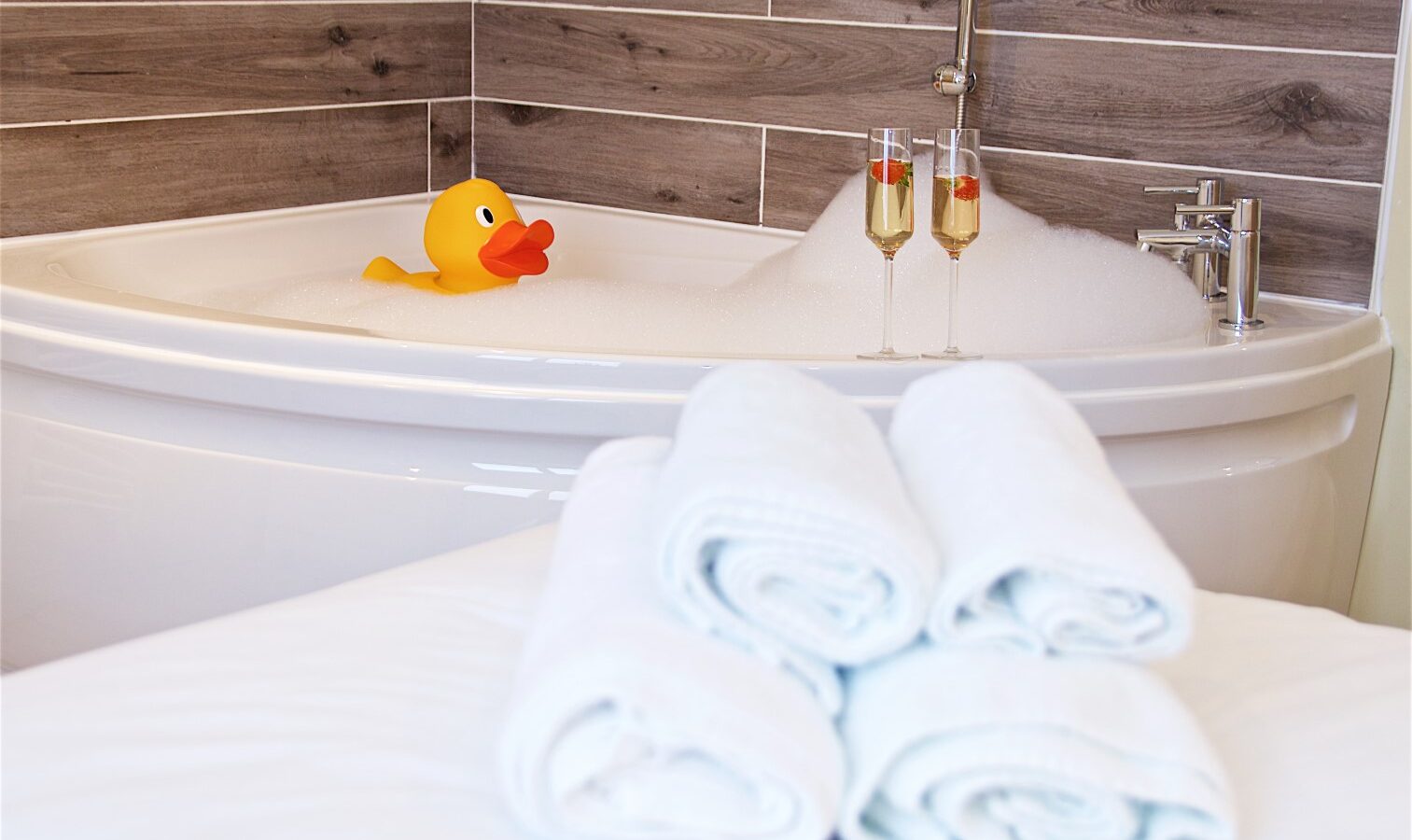 At Georges Getaway, unwind in a bathtub with bubbles and a rubber duck. Enjoy two champagne glasses perched on the edge and rolled towels on the side, offering pure relaxation.