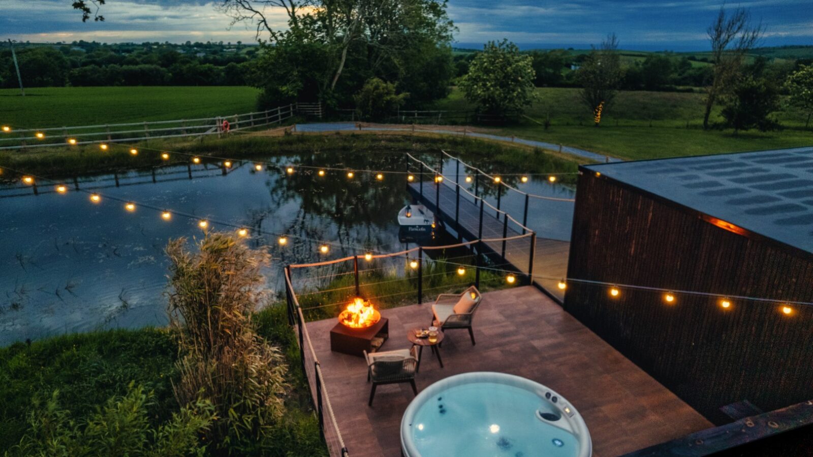 The Rusty Boathouse offers a stunning rooftop terrace featuring a hot tub, cozy seating, and an inviting fire pit. Overlooking the pond with twinkling string lights at dusk, this enchanting setting is perfect for boathouse dining at its finest.