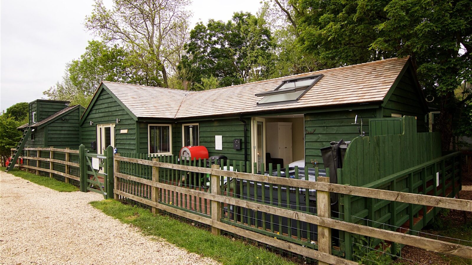 Nestled among the trees, Jess’ Tree Bach is a charming green wooden cottage with a fenced yard, patio grill, and skylight. This inviting holiday accommodation is adjacent to a gravel path, offering the perfect blend of rustic charm and modern comfort.