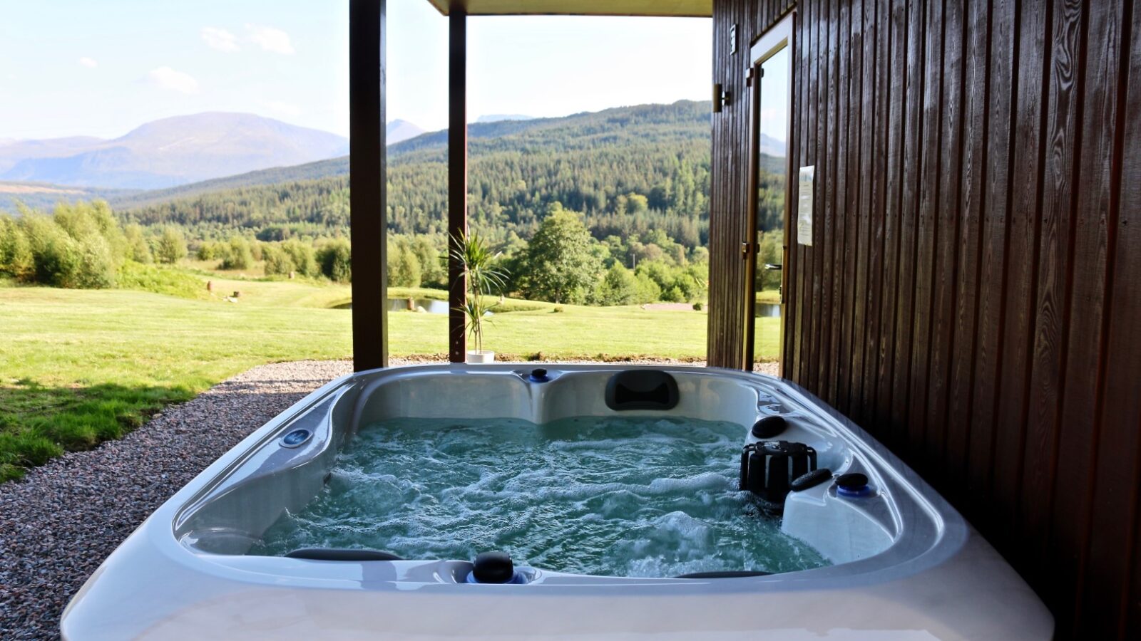 Outdoor hot tub with jets running, nestled under a wooden awning. With art tools in hand and the vista of grass and forested hills beyond, it’s the perfect spot for sketching inspiration into your Frances Sketch Pad.