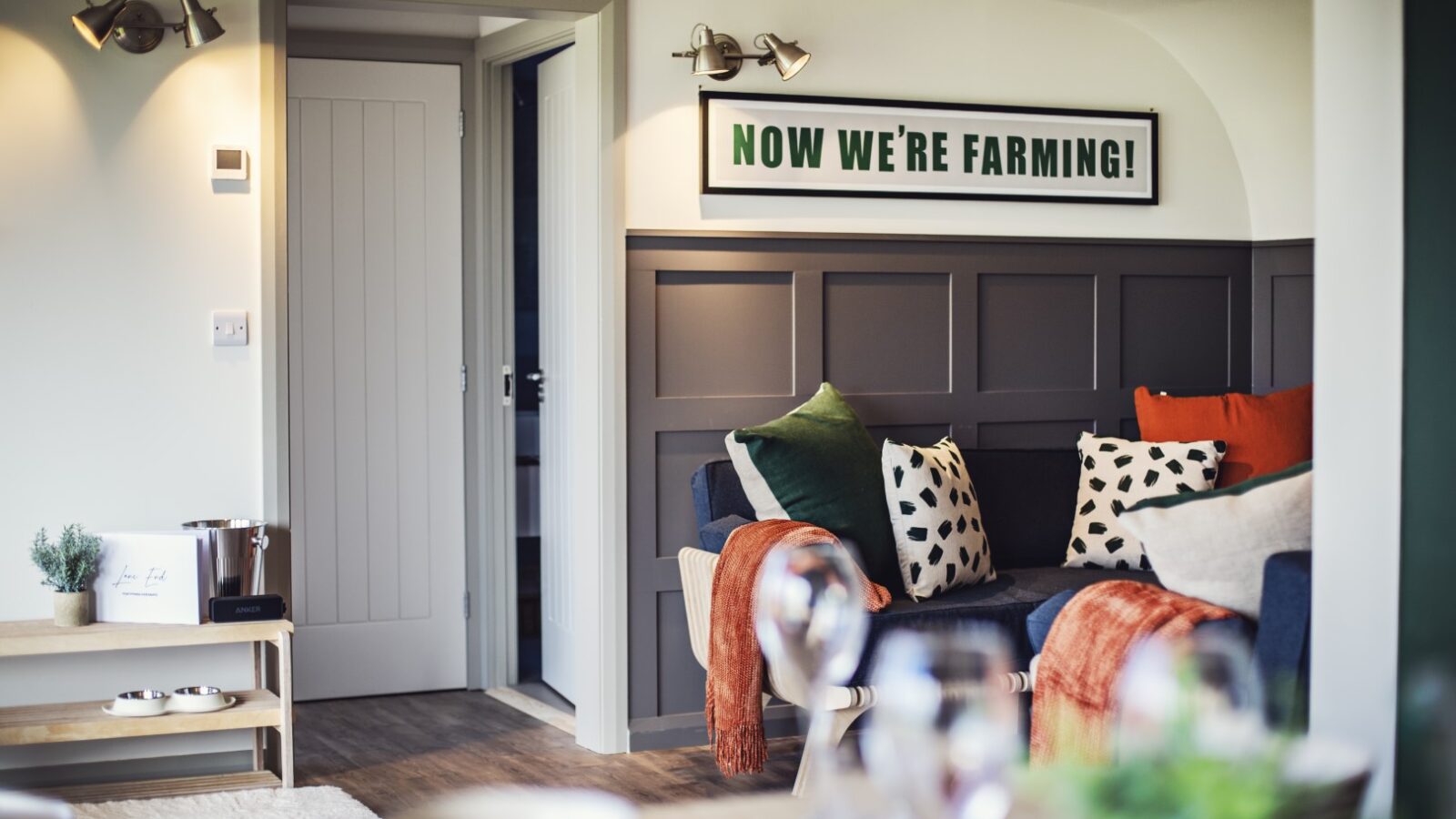 A cozy living area with a couch and pillows, a sign reading 