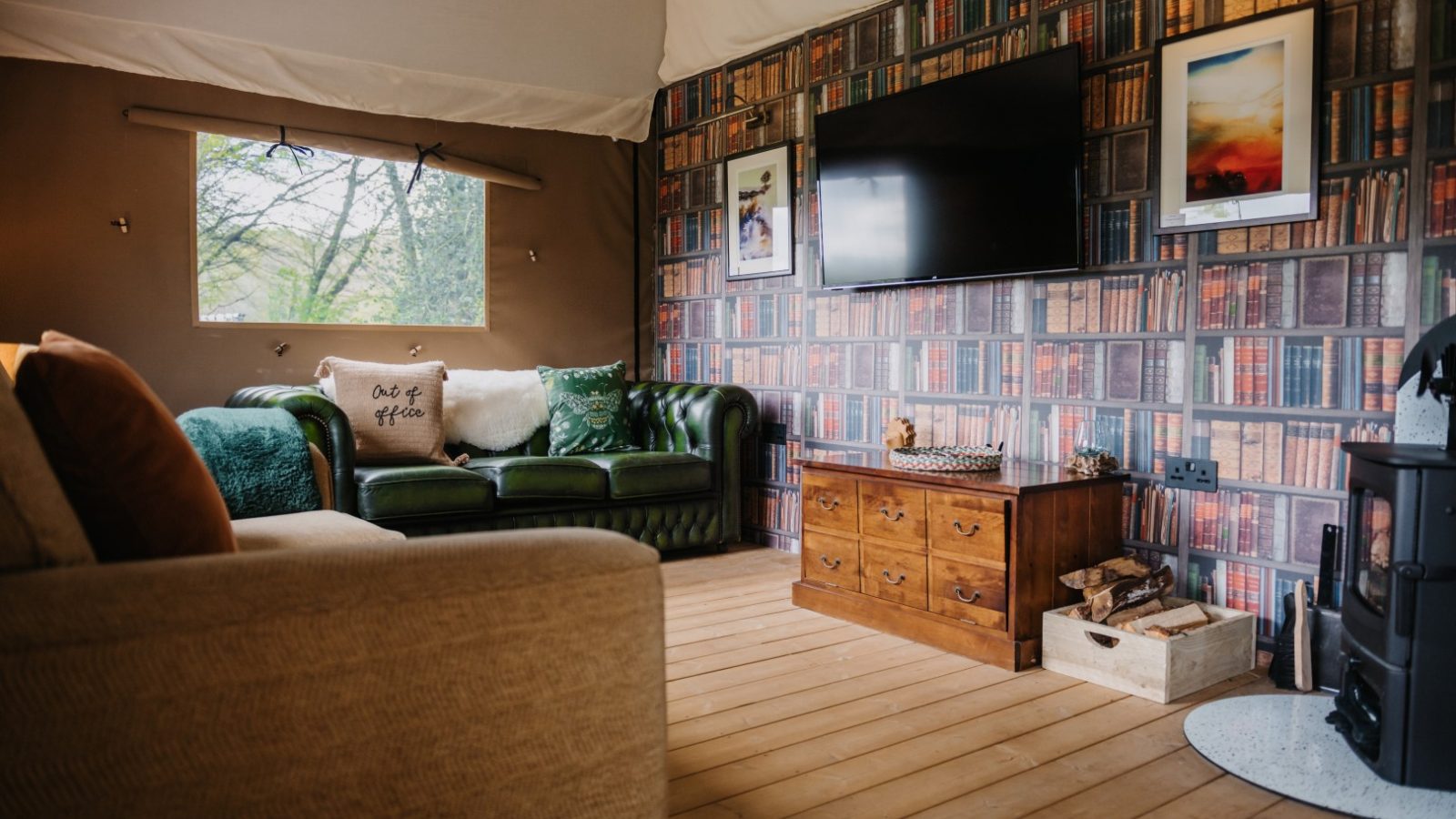 A cozy living room with a green leather sofa, cushion saying 