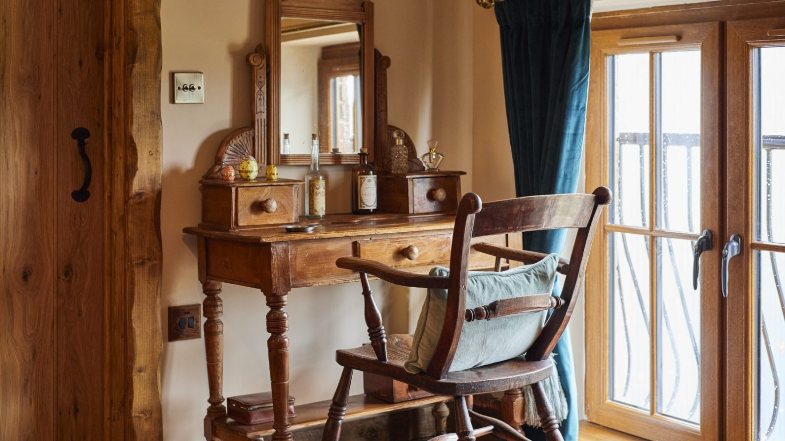 A wooden dressing table with a mirror and chair sits near a window at Gablebach, Black Mountain Escapes. The ideal getaway for a quintessential country cottage getaway