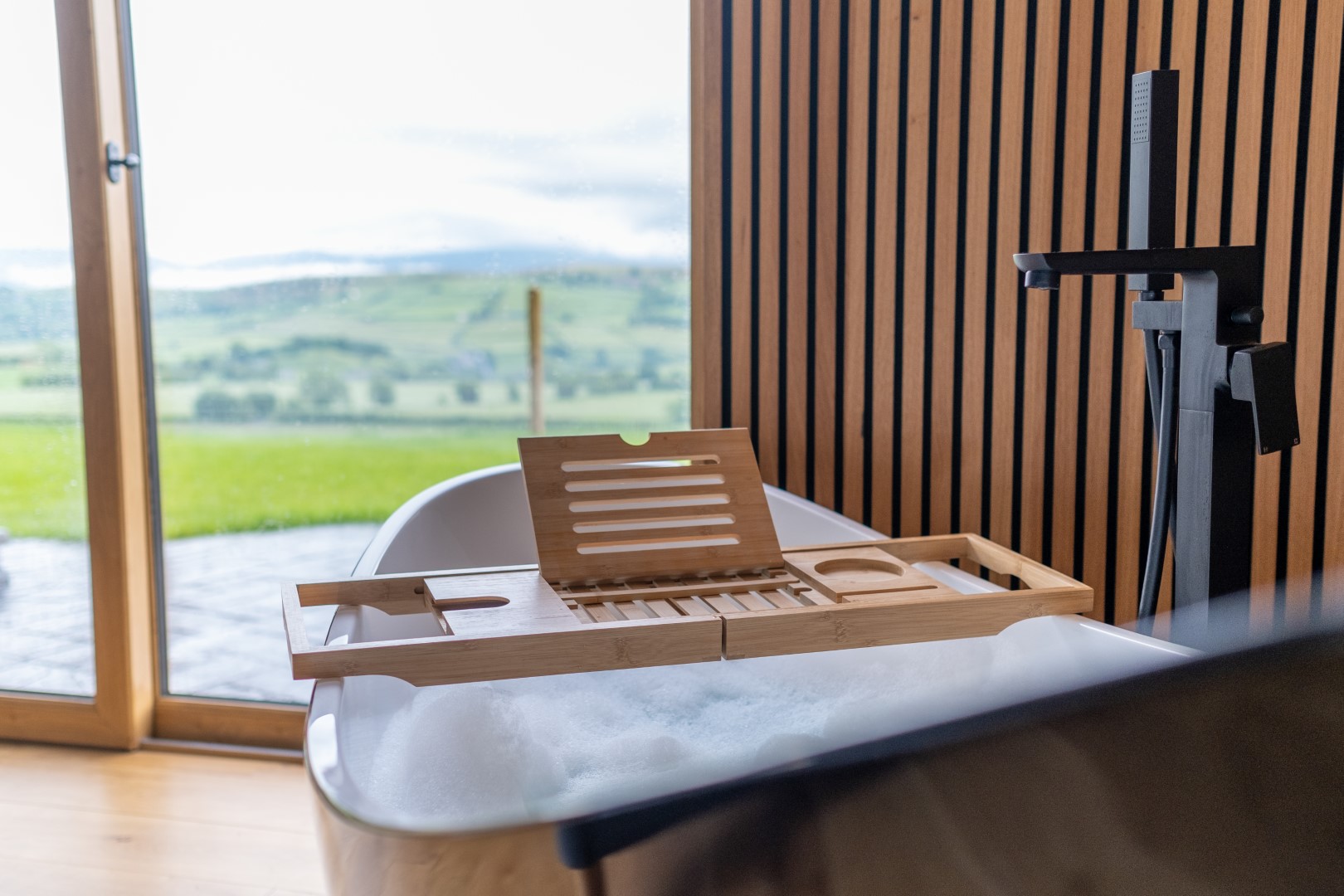 A hot tub with far reaching views over the welsh rolling hills, with sheep and mountains in the distance. Lundy Lodges in Wales is the ideal getaway location for a relaxing stay or one full of adventure. 