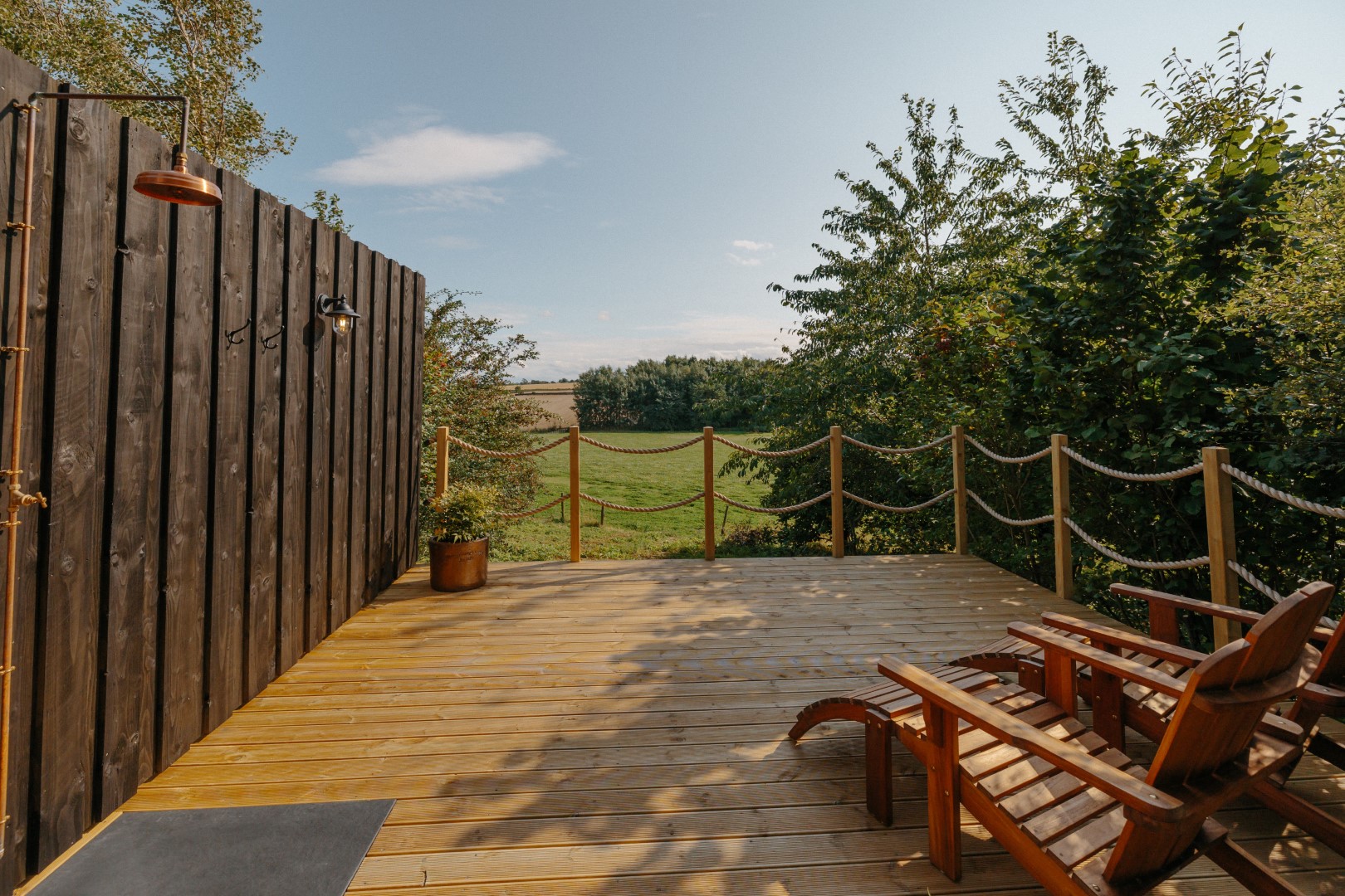 Hewn Yorkshire glass fronted woodland spa sauna nestles amongst the trees with a decking area and outdoor shower for a restorative break.