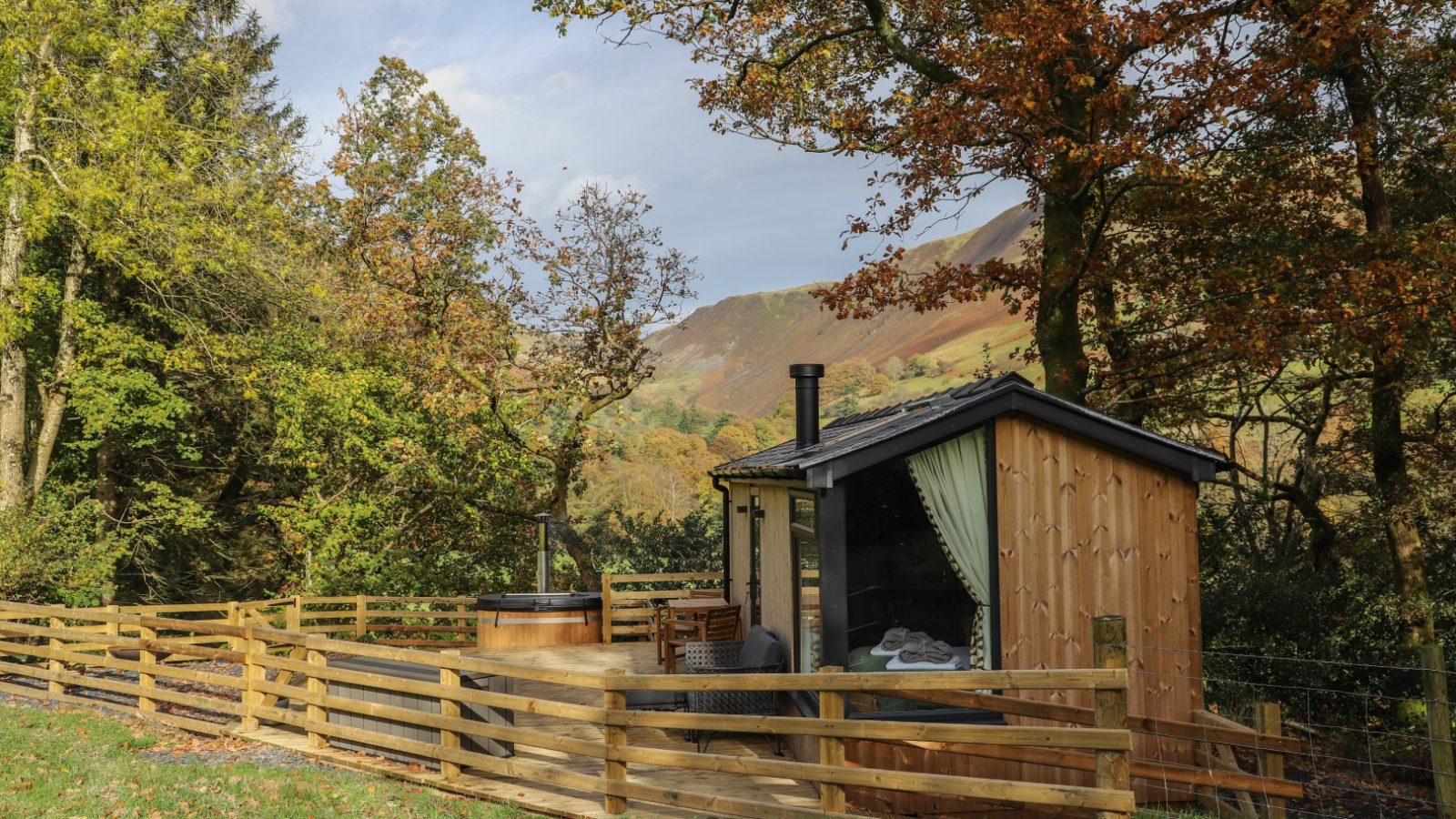 Nestled among autumn trees and rolling hills, this small wooden cabin is the perfect holiday retreat. With a hot tub on the patio, it's an ideal spot for peaceful gwyliau moments, offering relaxation and picturesque views just like a charming hideaway at Pennant.