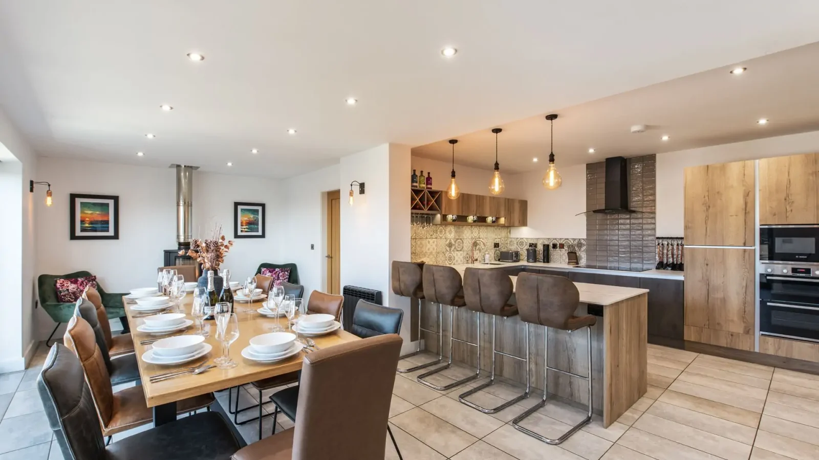 Spacious modern kitchen and dining area at Harbour Reach with wooden furniture, tiled floors, and large island lighting.