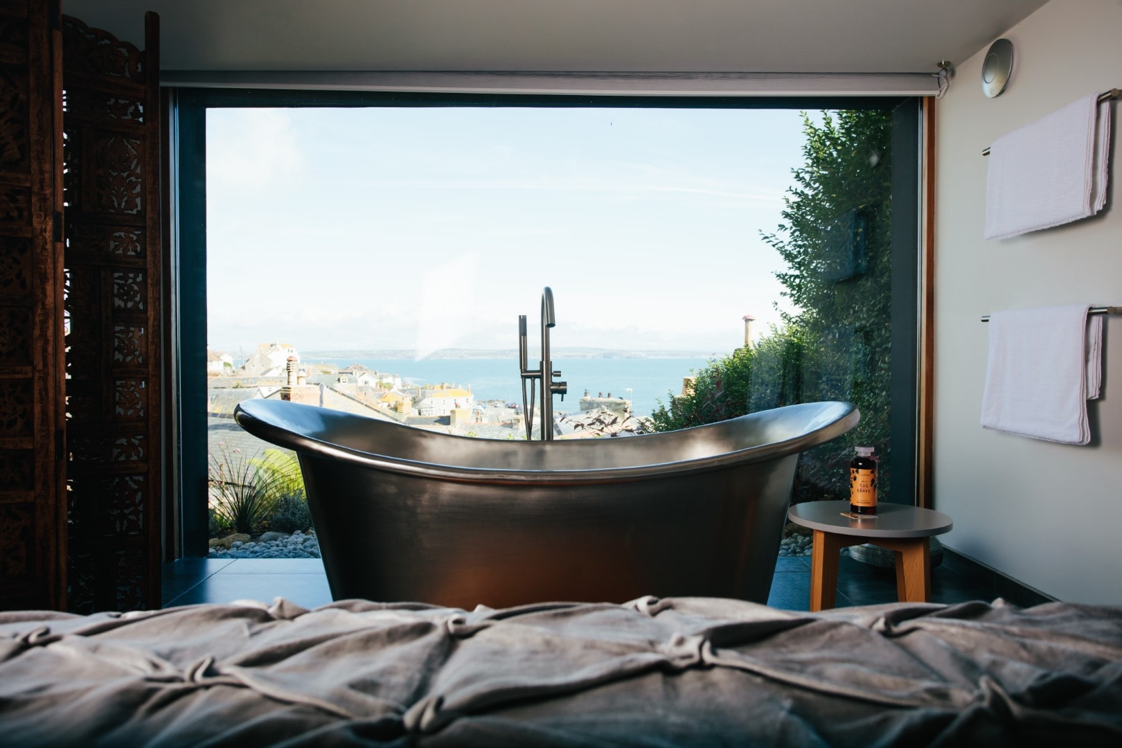 Romantic freestanding bathtub in a modern bathroom with a coastal view; perfect for dog-friendly breaks.