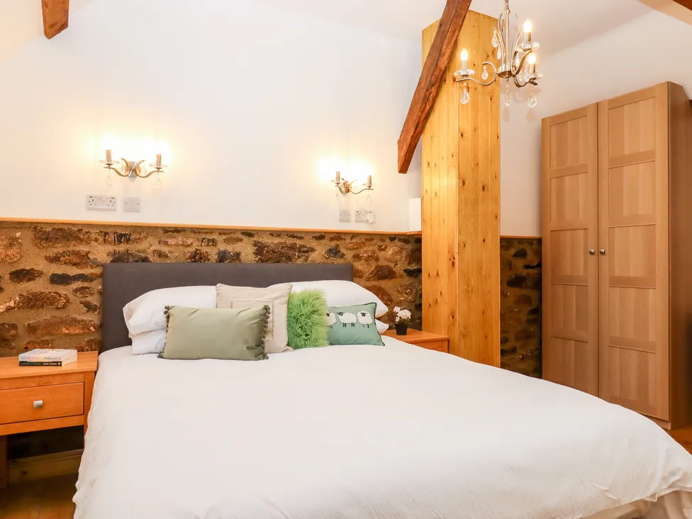 Cozy Bagtor Granary-style bedroom with a double bed, wooden features, side tables, soft lighting, and a wardrobe.