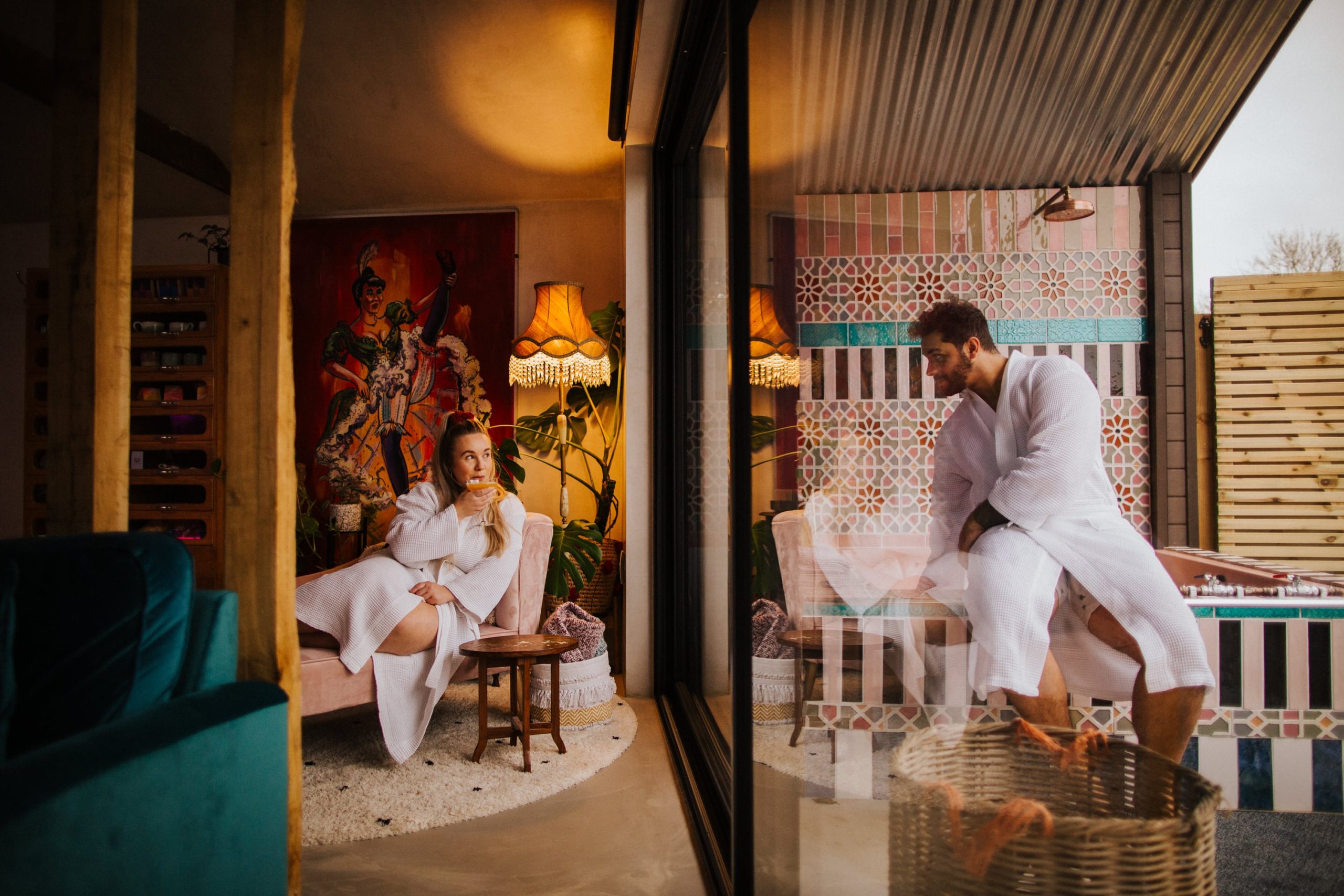 Couple look at each other through the window as the man runs a bath at bethnal & Bec Luxury Stays